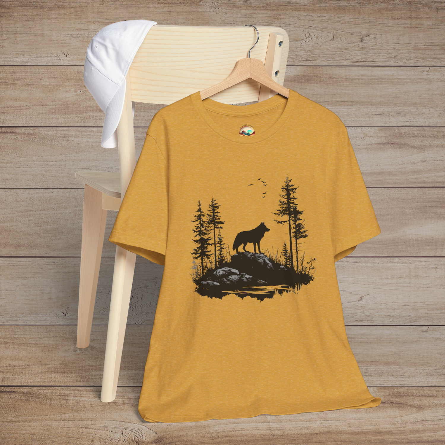Heather mustard yellow t-shirt featuring a lone wolf howling amidst a serene forest landscape with birds soaring in the sky, perfect for nature lovers