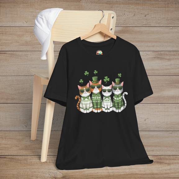 Black t-shirt featuring four stylish cartoon cats in green sweaters and sunglasses with floating shamrocks, perfect for St. Patrick’s Day