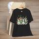 Black t-shirt featuring four stylish cartoon cats in green sweaters and sunglasses with floating shamrocks, perfect for St. Patrick’s Day