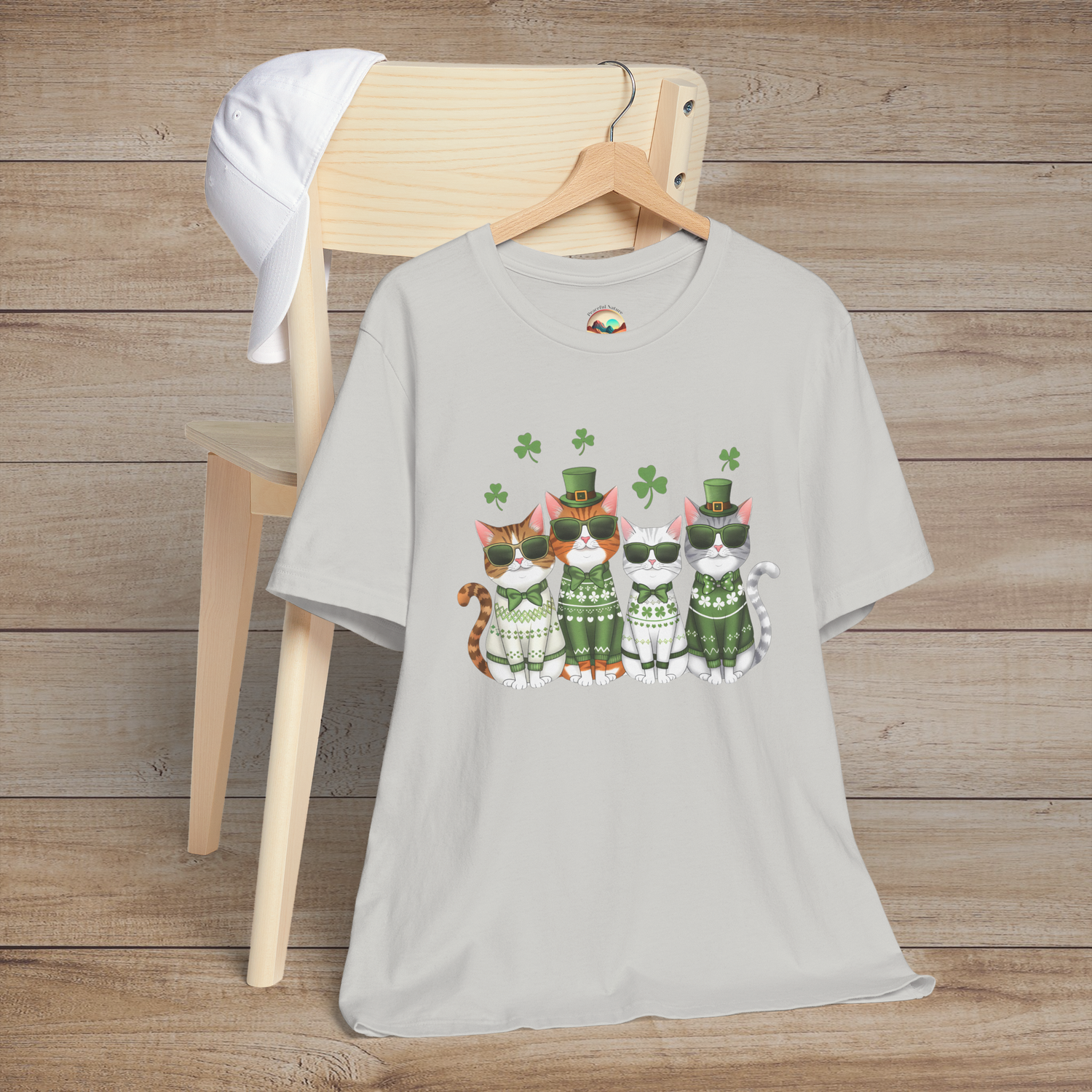 Silver t-shirt with a cute row of cartoon cats dressed for St. Patrick’s Day with green sweaters, clovers, and cool sunglasses