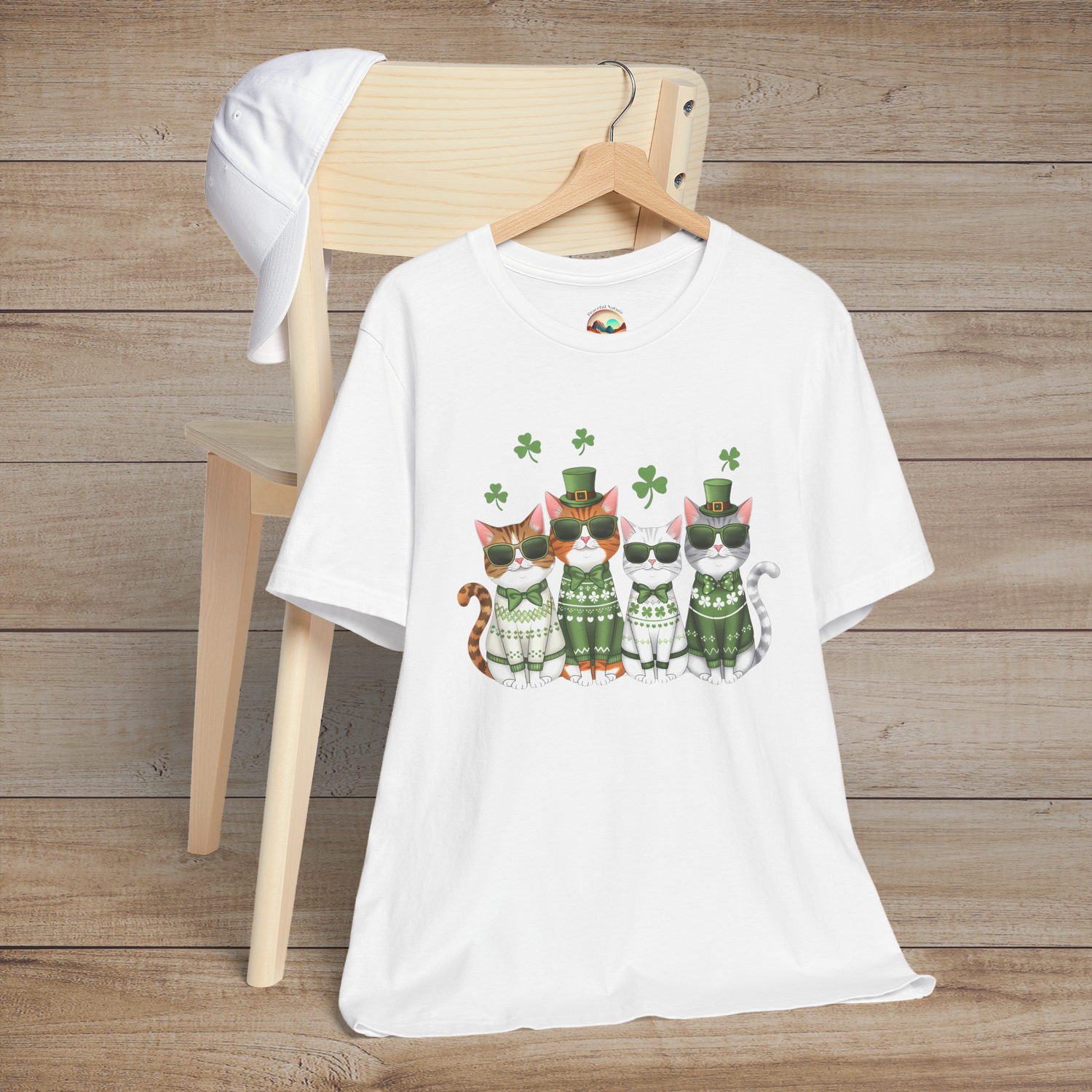 White t-shirt featuring adorable St. Patrick’s Day cats in festive green sweaters, glasses, and floating shamrocks