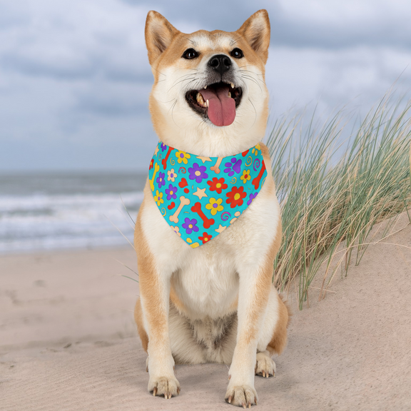 Medium-sized dog on sandy beach wearing bright bandana with playful design