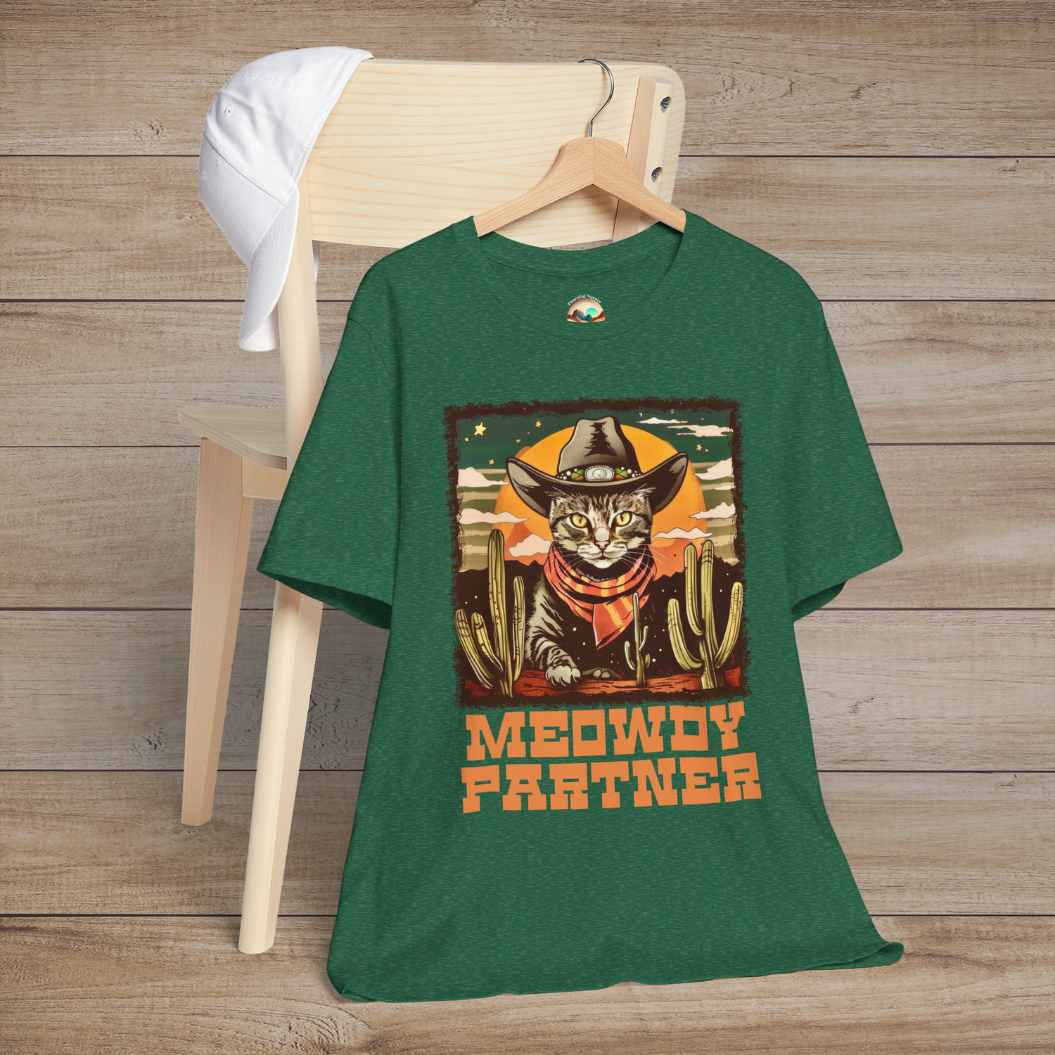 Heather Green Grass Meowdy Partner Funny Western Cat T-Shirt, displaying an adorable cowboy cat in hat and neckerchief amidst cacti scenery
