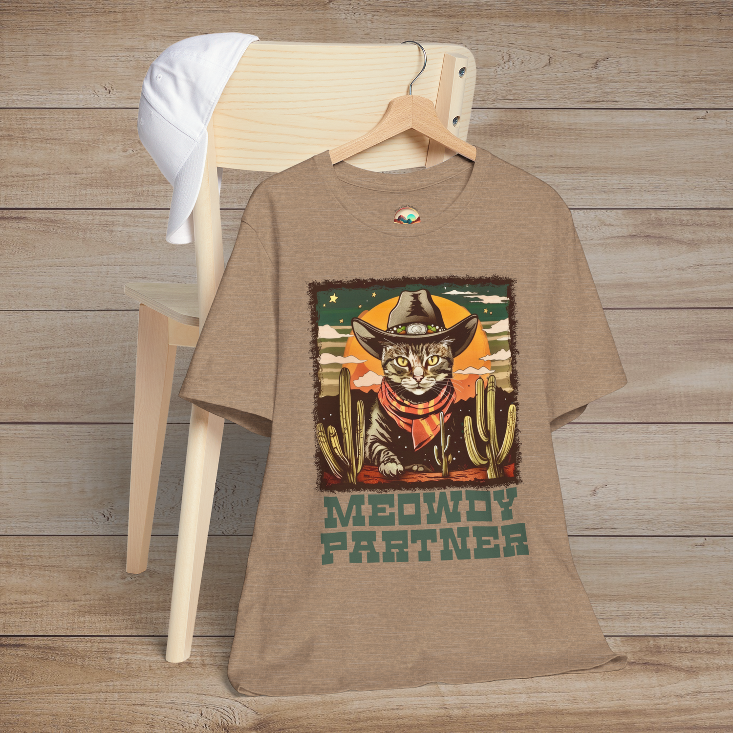 Heather Tan Meowdy Partner Western Cat Tee depicting a fun cat in cowboy gear, accented by desert cacti and retro Wild West graphics