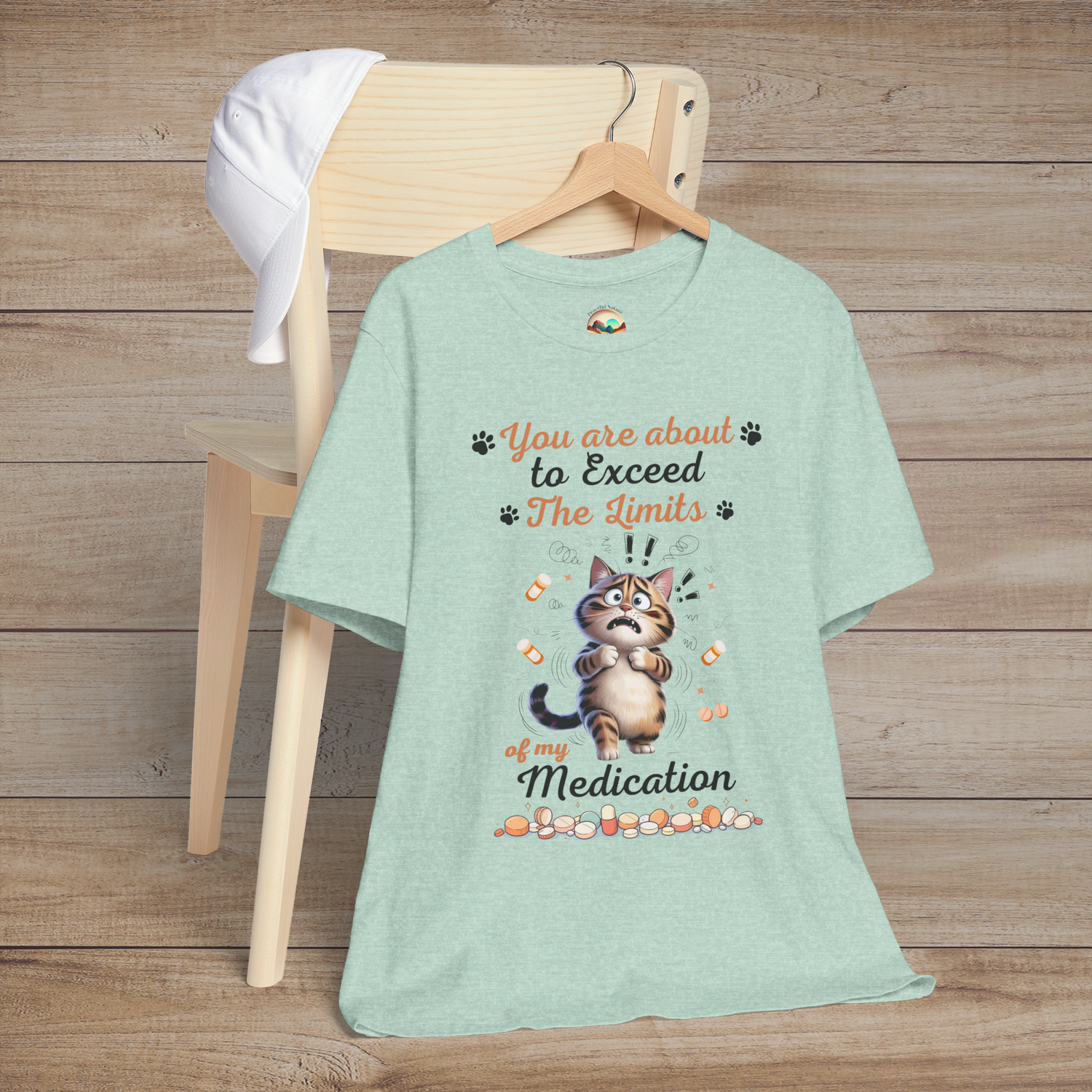 Funny heather prism mint green t-shirt with a cat graphic and text on a wooden chair.