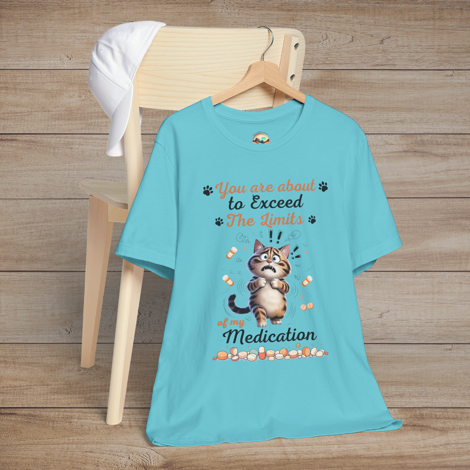 Funny turquoise t-shirt with a cat graphic and text on a wooden background