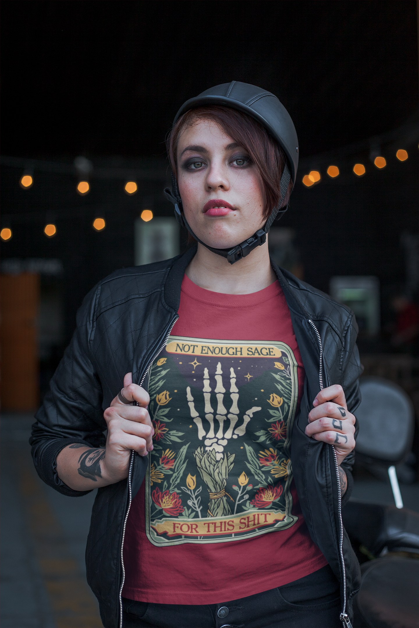 Confident female model in Canvas Red Not Enough Sage for This Sh*t Tee, styled with leather jacket and helmet, illustrating boho-goth vibe