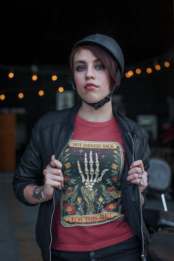 Confident female model in Canvas Red Not Enough Sage for This Sh*t Tee, styled with leather jacket and helmet, illustrating boho-goth vibe