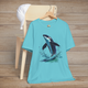 Turquoise Bella+Canvas tee with orca whale mid-leap in marine spray