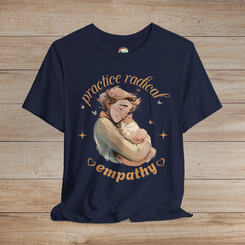 Navy blue shirt with emotional hand-drawn art of a person cuddling a happy cat, styled with golden hearts and butterflies and the phrase “Practice Radical Empathy.”