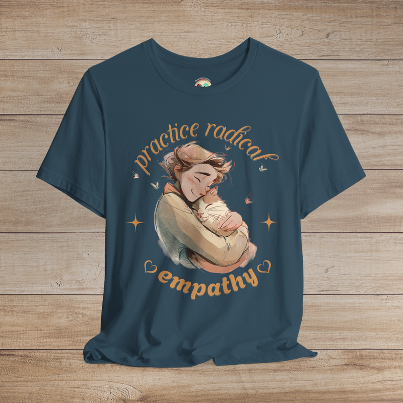 Teal shirt with emotional hand-drawn art of a person cuddling a happy cat, styled with golden hearts and butterflies and the phrase “Practice Radical Empathy.”