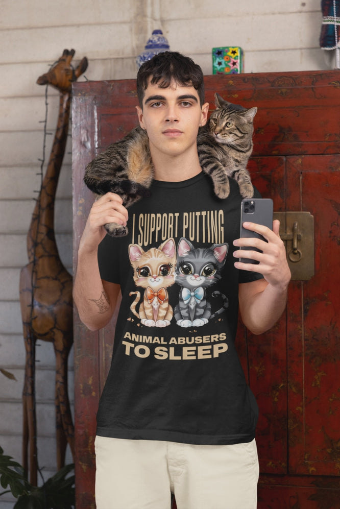 Video of man wearing a black t-shirt with cat graphics and animal advocacy text, holding a phone, with a cat on his shoulder.