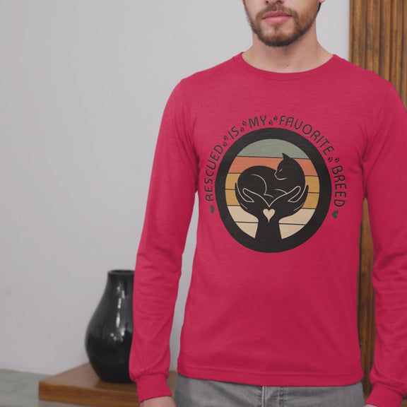 Video of man wearing True Red Sport-Tek long sleeve shirt with bright graphic and text saying "Rescued Is My Favorite Breed."