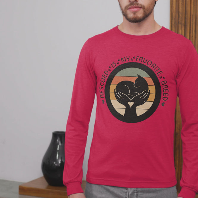 Video of man wearing True Red Sport-Tek long sleeve shirt with bright graphic and text saying "Rescued Is My Favorite Breed."