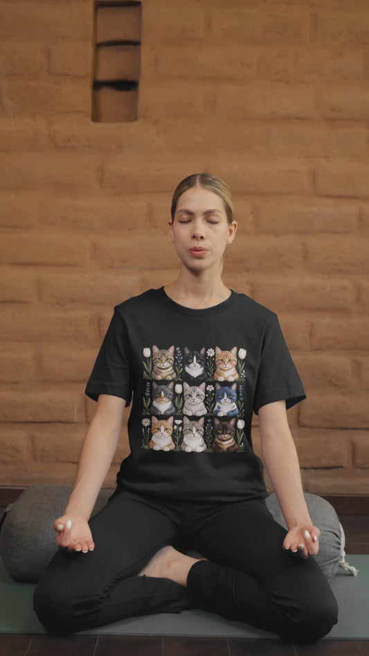 Video of a woman meditating while wearing a Bella Canvas 3001 T-shirt featuring a cottagecore nine-cat floral design