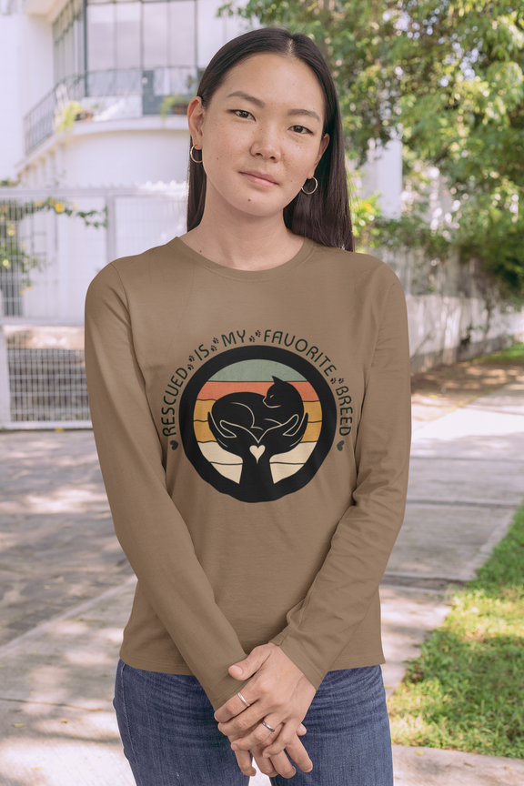 Woman wearing Woodland Brown Sport-Tek long sleeve shirt with bright graphic and text saying "Rescued Is My Favorite Breed."