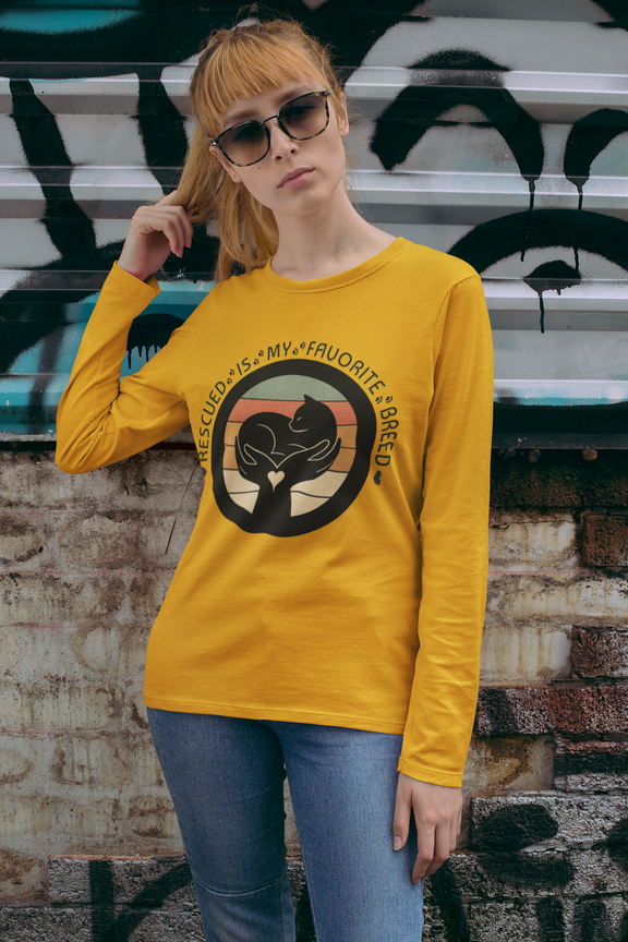 Woman wearing gold Sport-Tek long sleeve shirt with bright graphic and text saying "Rescued Is My Favorite Breed."