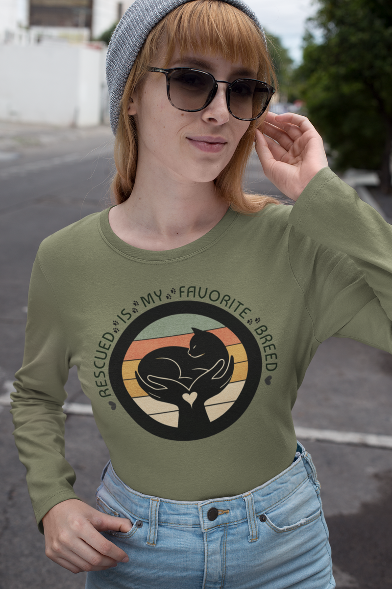 Woman wearing Olive Drab Green Sport-Tek long sleeve shirt with bright graphic and text saying "Rescued Is My Favorite Breed."