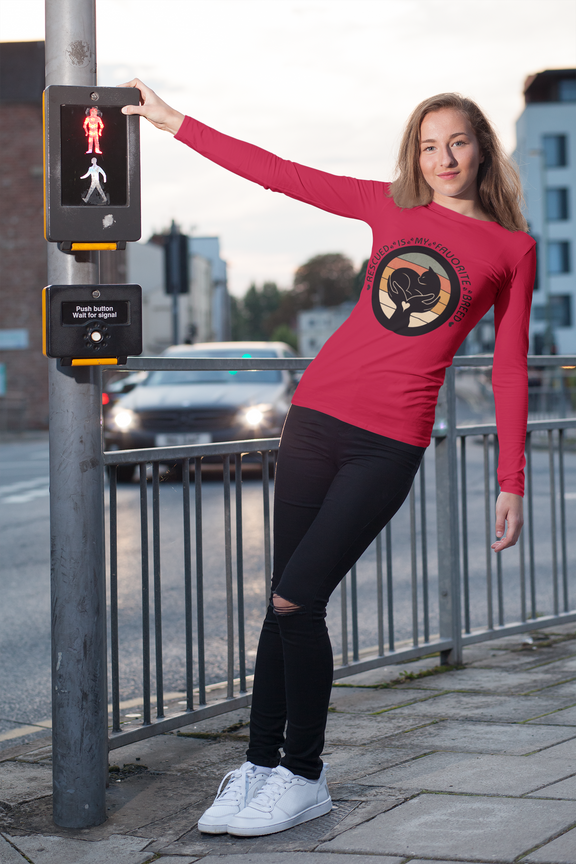 Woman wearing True Red Sport-Tek long sleeve shirt with bright graphic and text saying "Rescued Is My Favorite Breed."