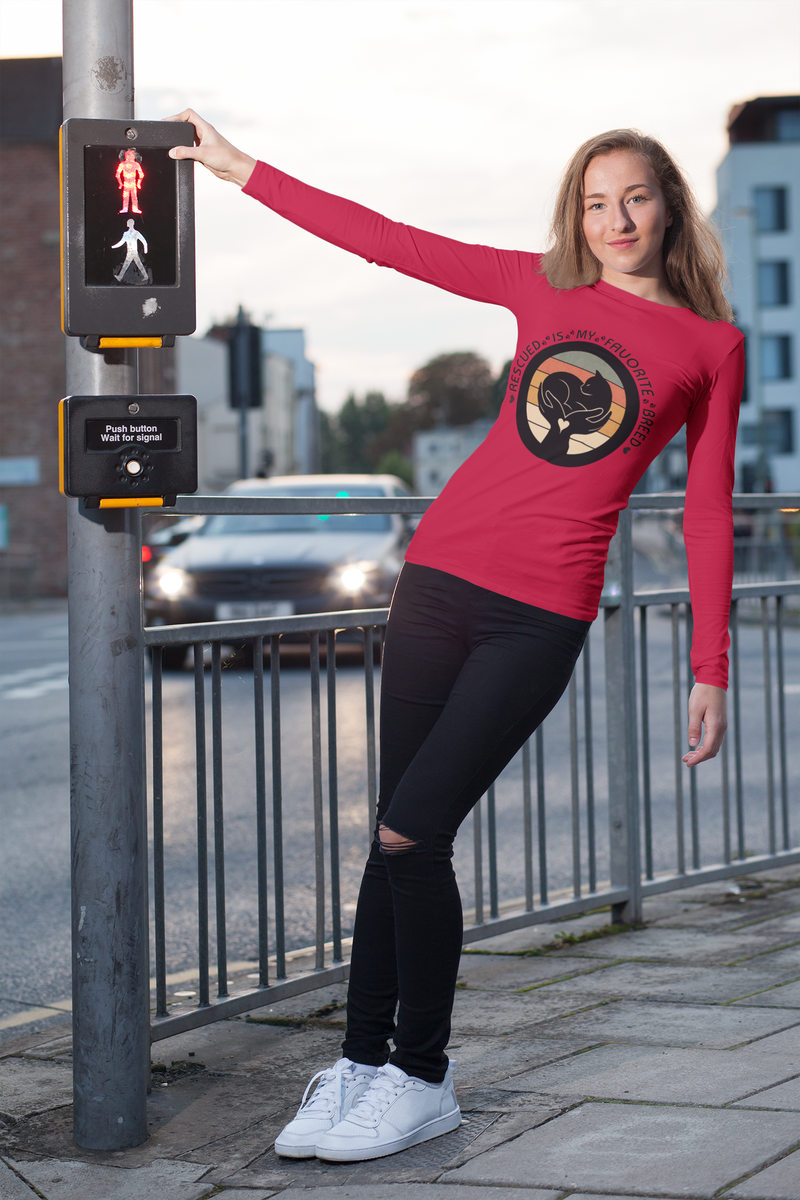 Woman wearing True Red Sport-Tek long sleeve shirt with bright graphic and text saying "Rescued Is My Favorite Breed."