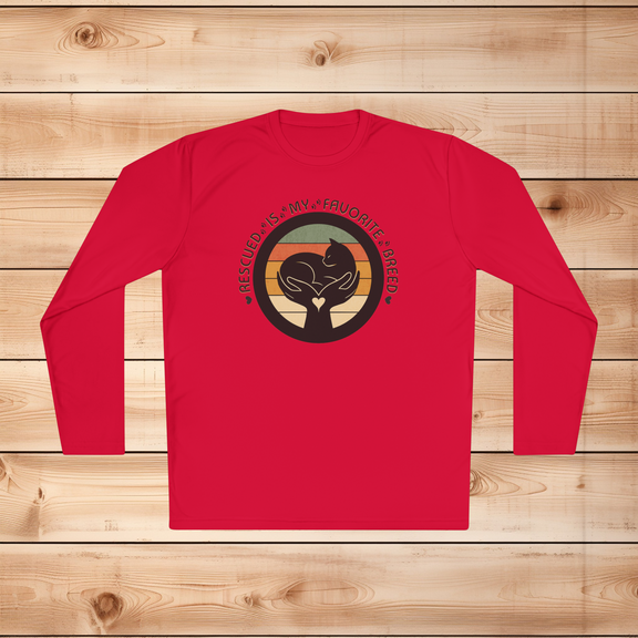 True red Sport-Tek long sleeve shirt with text saying "Rescued Is My Favorite Breed," with a black and white graphic on a wooden background