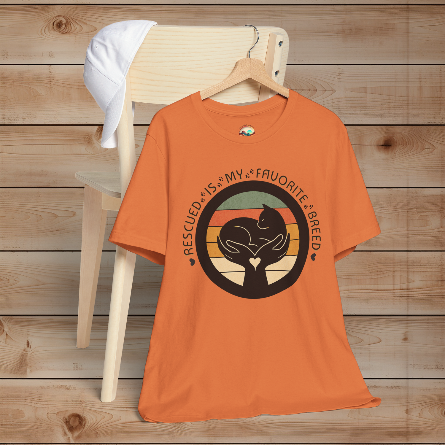 Burnt Orange ‘Rescued Is My Favorite Breed’ T-shirt – black cat graphic in gentle hands, retro sunset background, Bella+Canvas 3001
