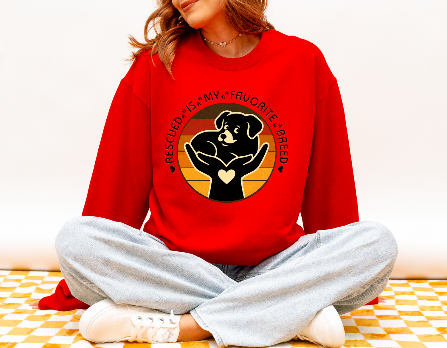 Model wearing bright red Gildan 18000 Rescued Is My Favorite Breed sweatshirt with vintage sunset dog rescue artwork.