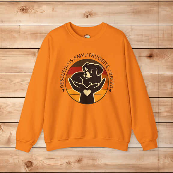 Safety orange Gildan 18000 Rescued Is My Favorite Breed crewneck sweatshirt with bold black dog and sunset design supporting animal adoption.