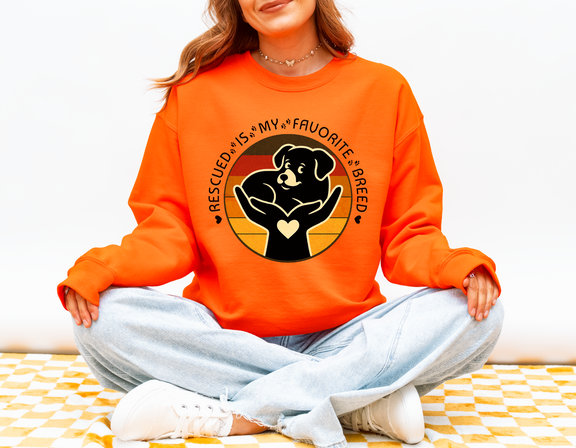 Woman wearing safety orange Rescued Is My Favorite Breed Gildan 18000 sweatshirt supporting animal rescue and adopt-don’t-shop awareness