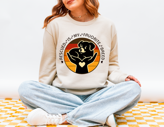Model in sand color Gildan 18000 Rescued Is My Favorite Breed sweatshirt showing dog and heart design symbolizing compassion for rescues.
