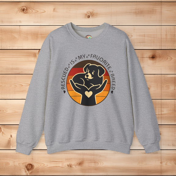 Sport grey Gildan 18000 Rescued Is My Favorite Breed sweatshirt featuring a black dog design in loving hands with a retro sunset background