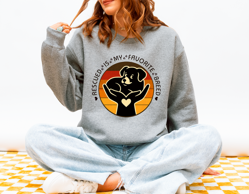 Woman wearing sport grey Gildan 18000 Rescued Is My Favorite Breed sweatshirt featuring black dog in hands design promoting pet adoption