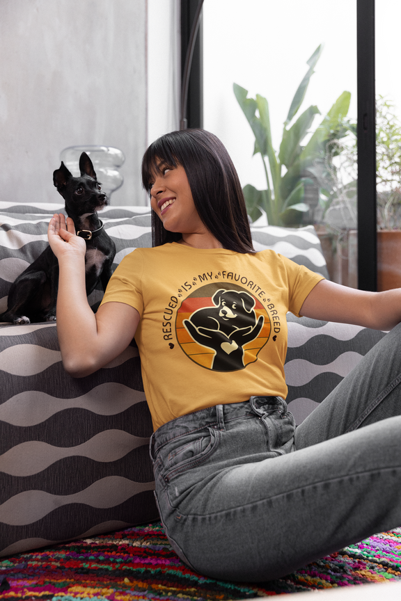 Woman wearing Rescued Is My Favorite Breed T-Shirt in Gold while relaxing with her rescue dog – Retro Dog Adoption Shirt by Peaceful Nature Designs