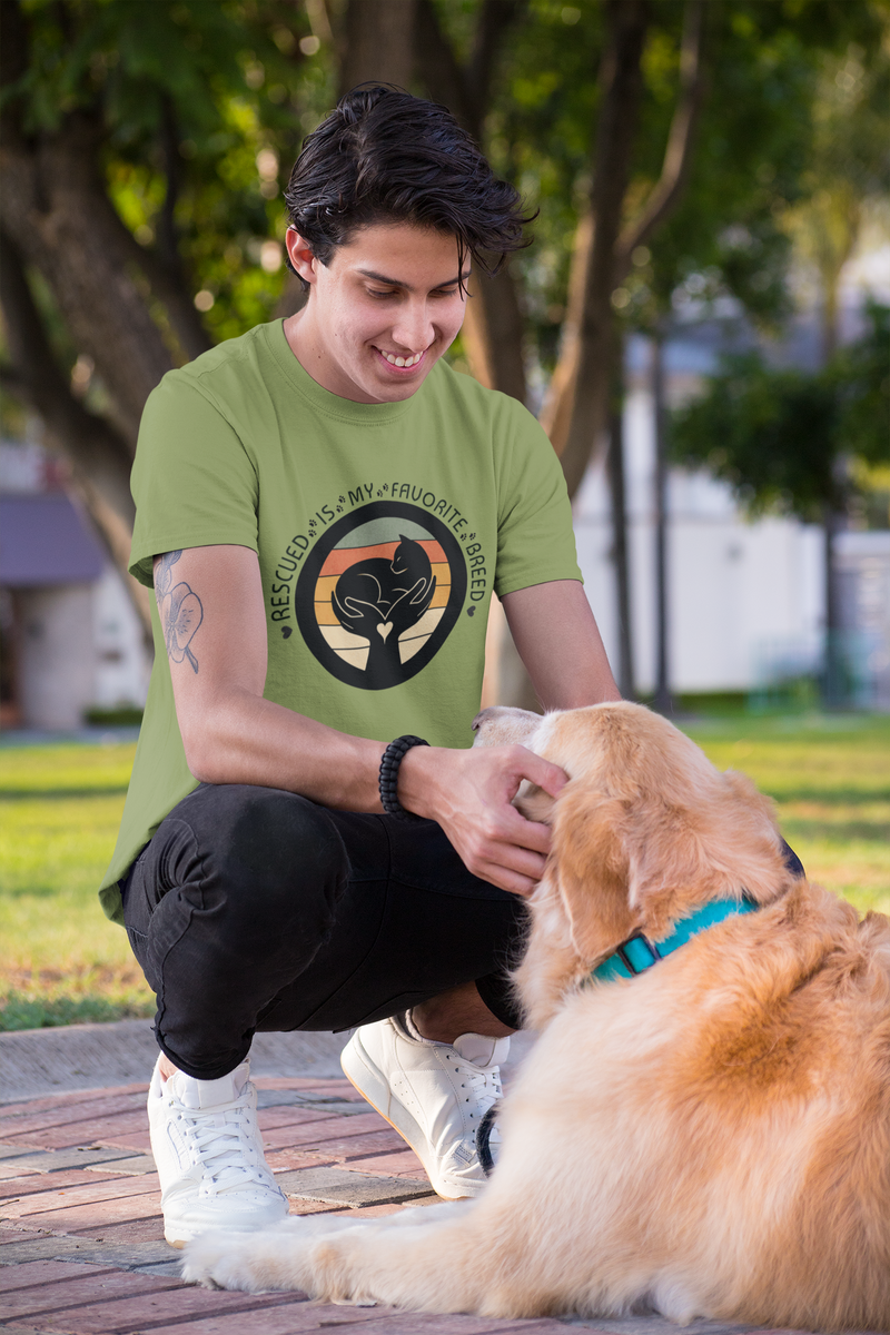 Man wearing Rescued Is My Favorite Breed T-Shirt in Heather Green outdoors with his golden retriever – Humane Society Support Tee for Dog Lovers