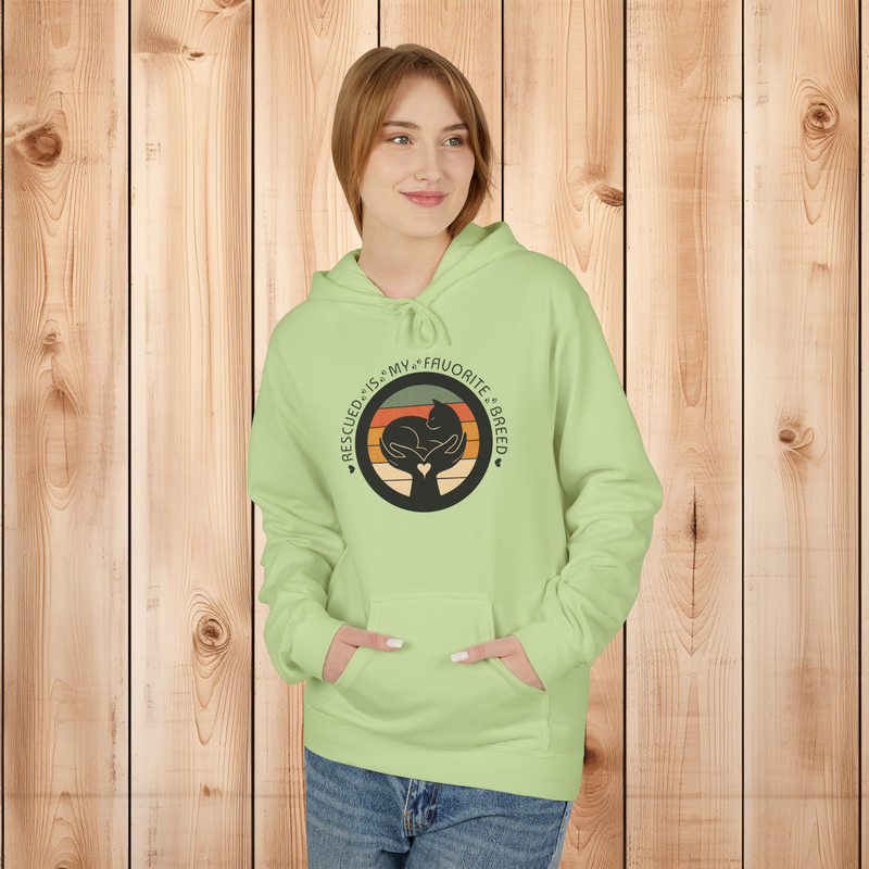 Model wearing a pistachio green 'Rescued Is My Favorite Breed' retro cat rescue hoodie standing against a wooden backdrop