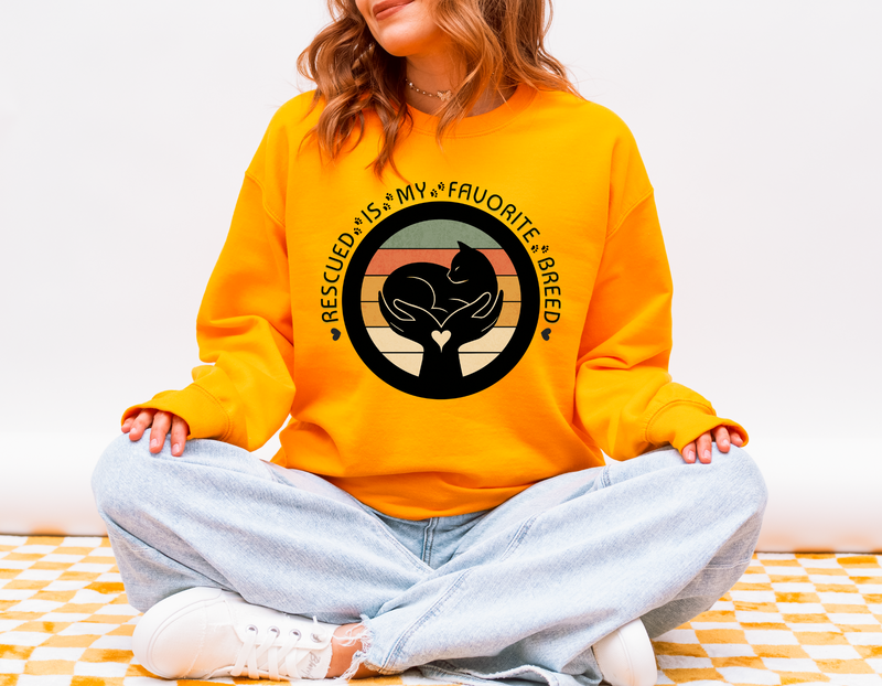 Woman wearing gold Gildan 18000 Rescued Is My Favorite Breed sweatshirt promoting animal rescue and pet adoption awareness