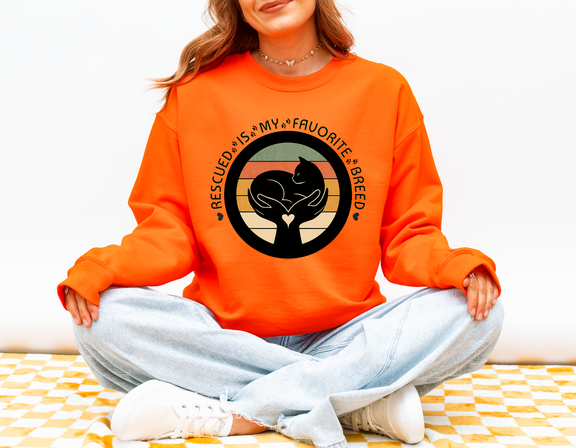 Bright safety orange Gildan 18000 sweatshirt with Rescued Is My Favorite Breed design for animal rescue supporters and dog cat lovers