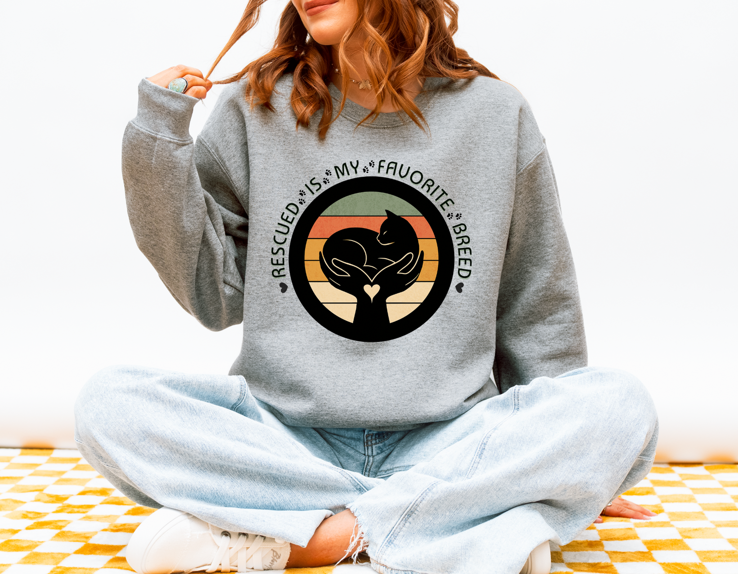 Person wearing sport grey Gildan 18000 Rescued Is My Favorite Breed crewneck sweatshirt for cat and dog lovers supporting rescue and adoption.