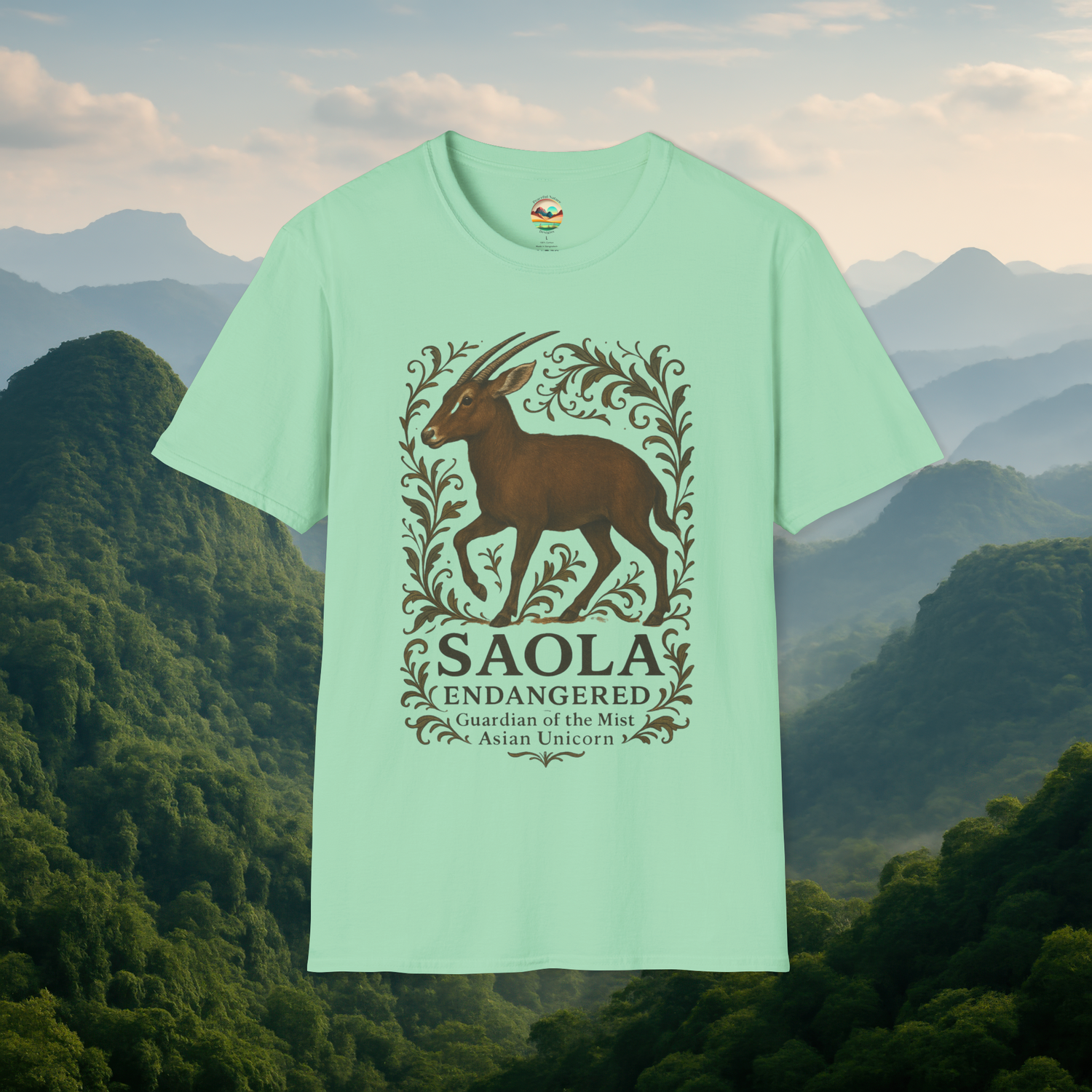Saola Endangered Asian Unicorn T-Shirt in Mint Green – Artistic rendering of the endangered Saola framed by leaves and vines. Soft, breathable eco-conscious cotton tee shown with misty mountain scenery