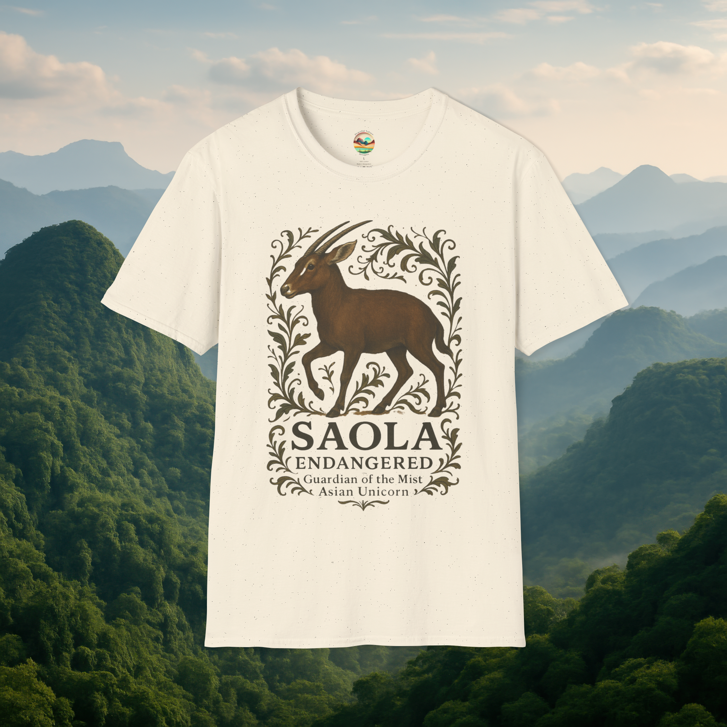 Saola Endangered Asian Unicorn T-Shirt in Natural – Premium soft cotton tee featuring an endangered Saola surrounded by botanical artwork. Presented against a peaceful misty forest backdrop