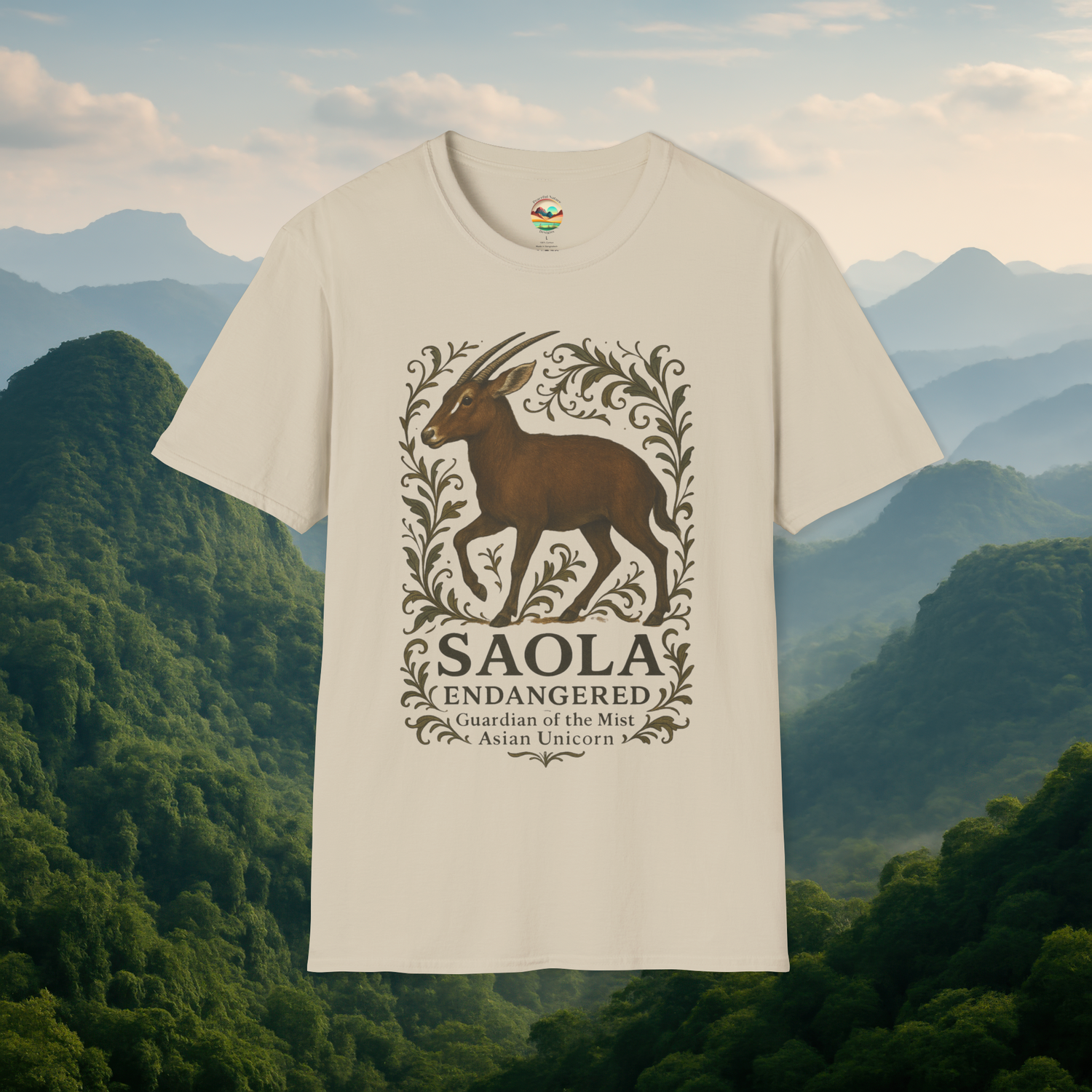 Saola Endangered Asian Unicorn T-Shirt in Sand – Endangered Saola design framed with nature-inspired vines. Eco-friendly lightweight t-shirt photographed with lush misty mountains behind