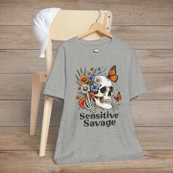 Heather gray t-shirt featuring a skull with a skeleton hand holding colorful flowers and butterflies with the text Sensitive Savage
