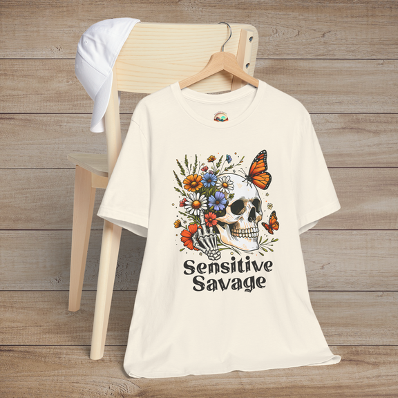 Natural-colored t-shirt featuring bold Sensitive Savage text with a skull holding blooming flowers and surrounded by butterflies