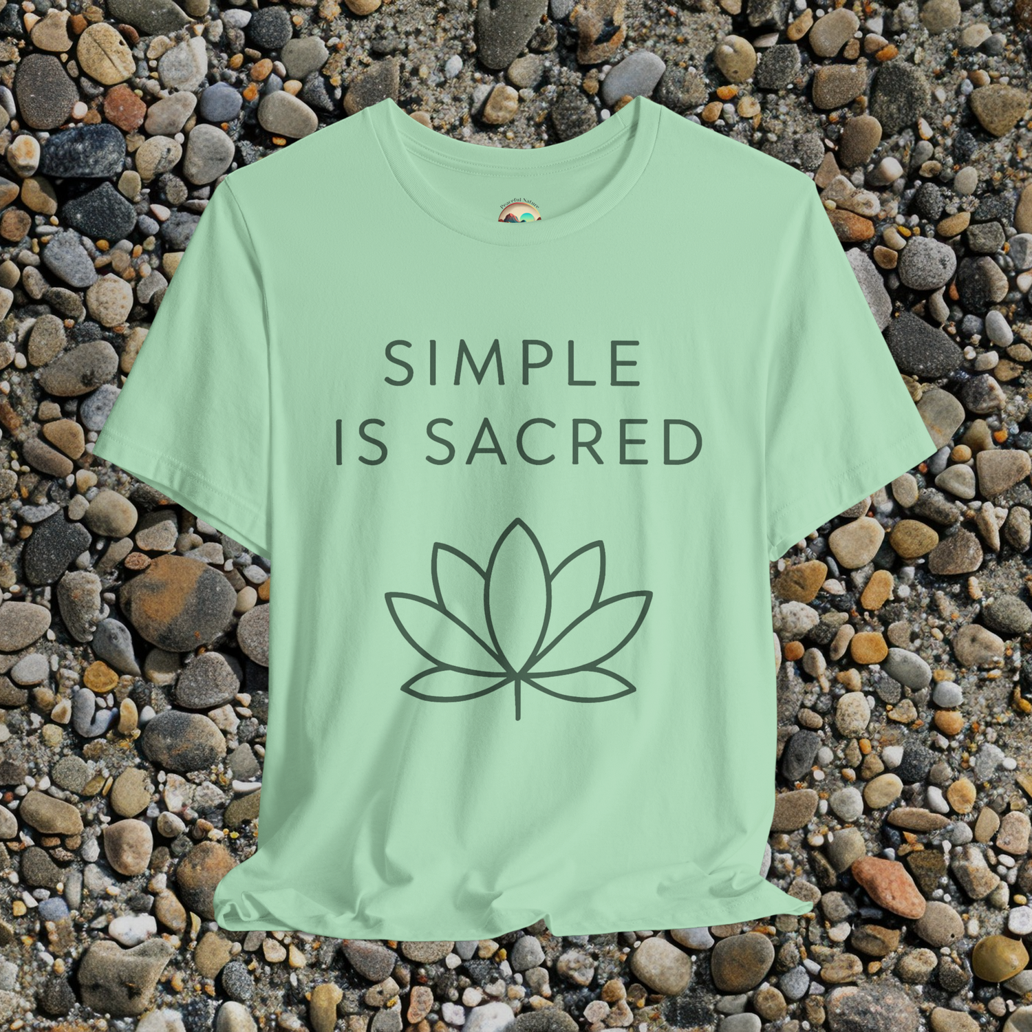 Fresh mint green tee with dark green "Simple Is Sacred" print and abstract lotus icon