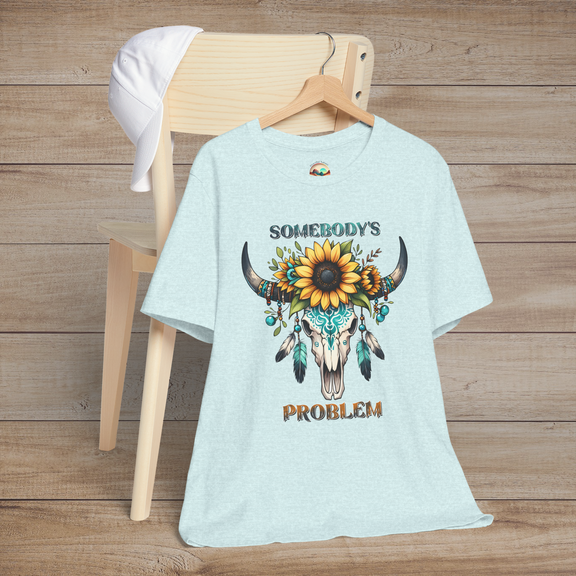 Somebody’s Problem T-Shirt showing a detailed western skull with colorful Boho accents on heather prism ice blue fabric