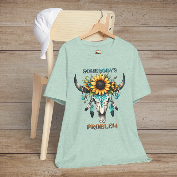 Somebody’s Problem T-Shirt featuring a stylish Bohemian skull graphic with sunflowers and turquoise feathers on heather prism mint fabric