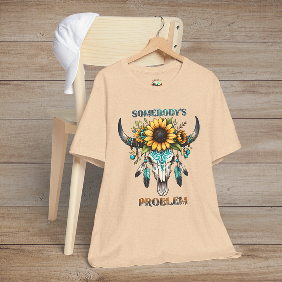 Somebody’s Problem T-Shirt with a striking Boho western skull, sunflower crown, and turquoise details on heather sand dune fabric