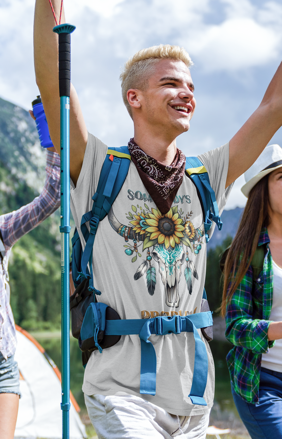 Smiling hiker wearing Somebody’s Problem T-Shirt in silver with a colorful Boho skull, sunflowers, and feathers design