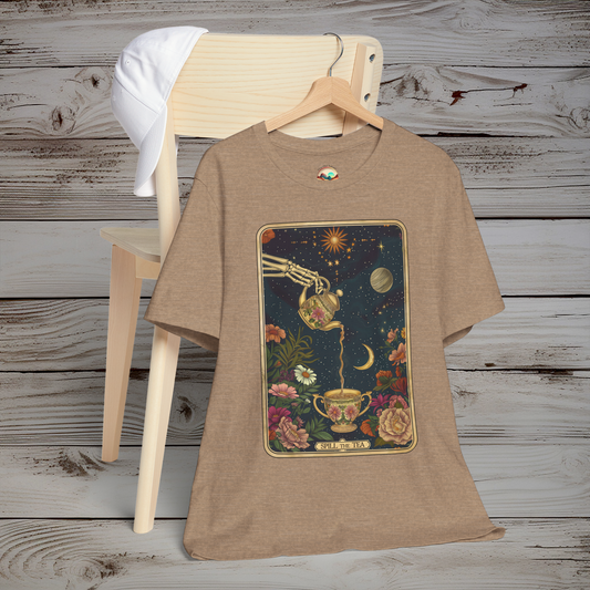 Flat lay of Spill the Tea T-Shirt in heather tan color on a chair with wooden background