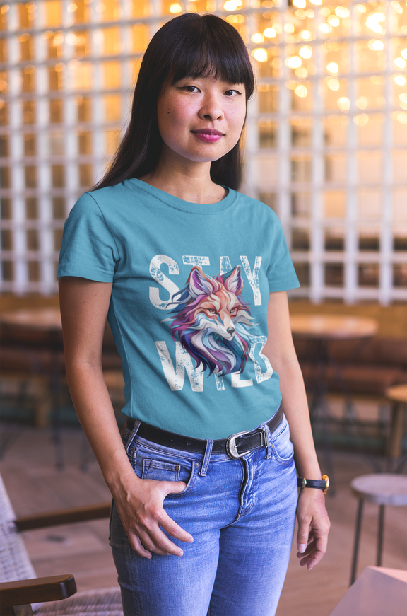 Woman wearing Aqua Stay Wild Fox t-shirt with colorful fox design indoors